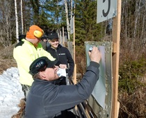Ammunnanjohtaja Reijo Pekkarinen( edessä) ja Matti Rossi kirjaamassa Kati Markkasen tulosta.