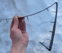 Eräs aseen hankalimmin sovitettavista osista; yksiosainen perälevy, joka suojaa tukkia kolmelta eri sivulta. Kiinnitysnaulat on taottu 3 mm rautalangasta.