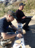 Rauno Straniuksen kilpailutoimisto kulkee kätevästi vaikka nuotiopaikalle. Antti Liimatainen valmistelee palkintoja jakokuntoon.